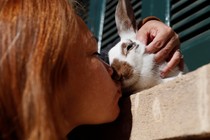 A woman kisses a rabbit. 