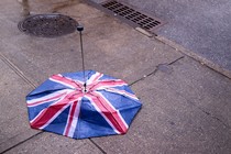 British flag umbrella turned inside out on a wet sidewalk