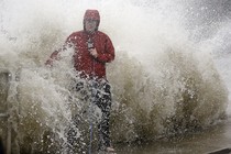 A news reporter doing a stand up near a sea wall in Cedar Key, Fla., is covered by an unexpected wave as Hurricane Hermine nears the Florida coast, Thursday, Sept. 1, 2016.