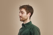Man in green shirt closes his eyes