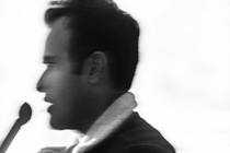 Blurry black-and-white photo of Vivek Ramaswamy speaking into a microphone