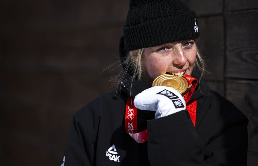 An athlete is seen biting a newly won gold medal.