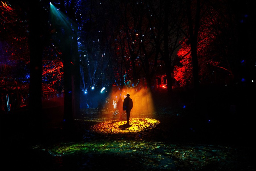 A person walks through a beam of light in a large art installation.