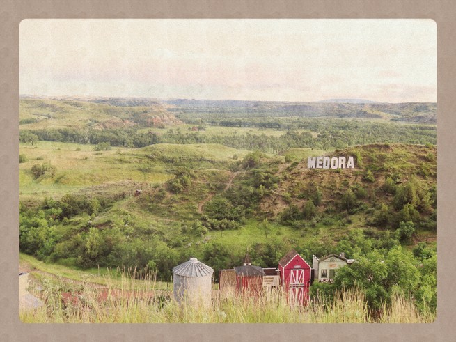 A view overlooking a valley with a sign that says Medora