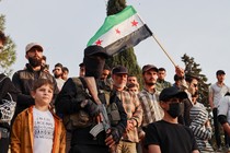 In Idlib, Syria, on May 4, protesters against Israeli strikes include a child, a man waving a Syrian flag, a masked gunman, and many others.