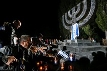 People place candles and Israeli flags during a ceremony commemorating the victims of Babi Yar on September 29, 2016.