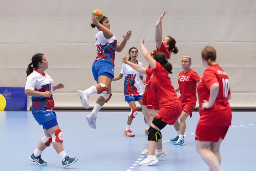 Players compete during a handball match.