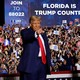 Donald Trump in a red tie and blue suit at a Florida rally