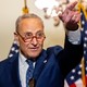 Senator Chuck Schumer pointing in front of American flags
