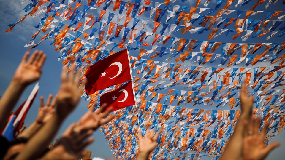 Supporters wave their hands in front of a Turkish flag