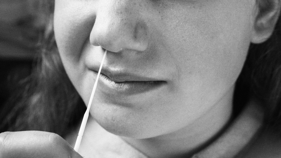 a girl swabs herself for a rapid antigen test for the coronavirus