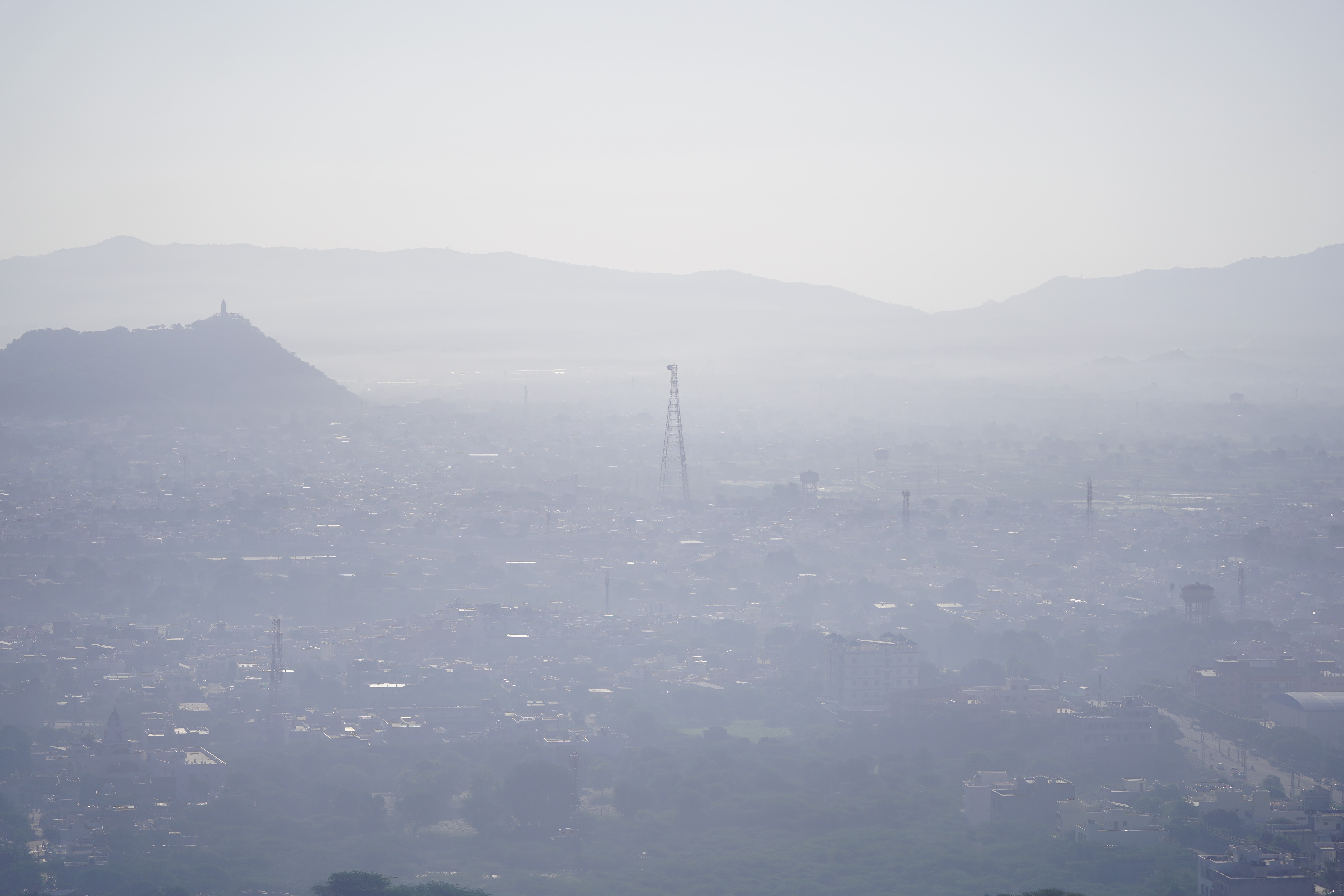 An elevated view of a city and surrounding Hills, all covered in a blanket of smog