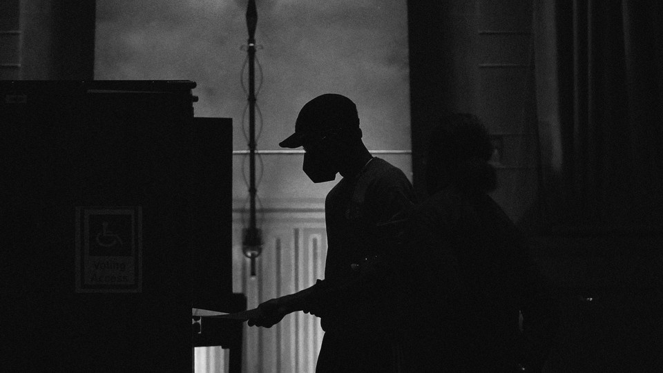 person wearing a hat and mask voting