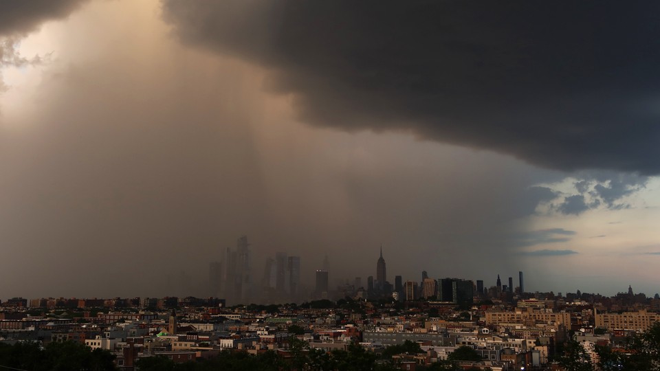 Dark rain clouds hover over the New York City skyline.