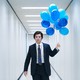Mark (Adam Scott) carrying blue balloons in an office corridor on "Severance"