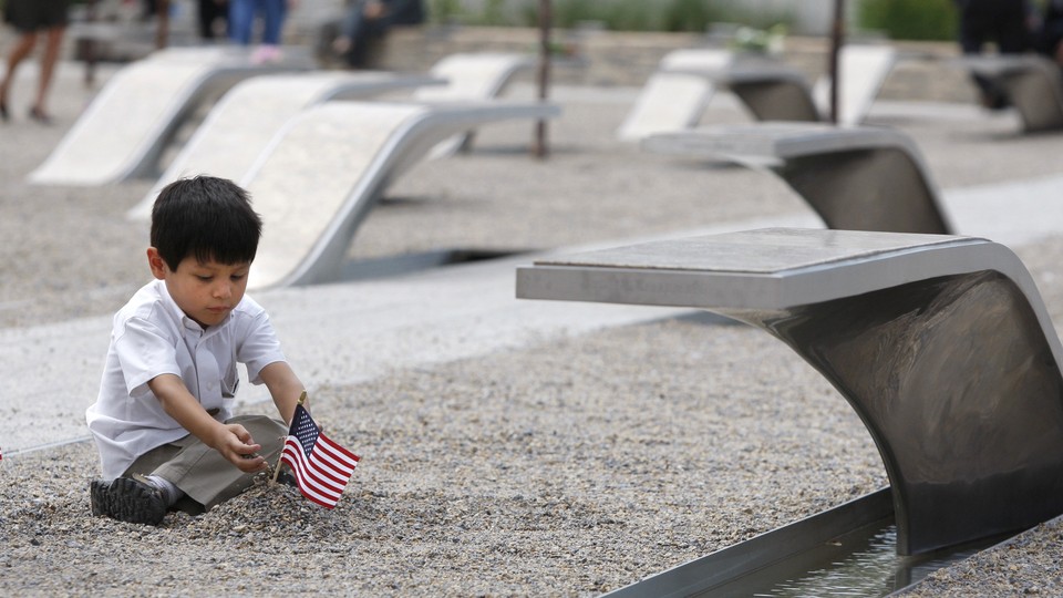 A child plays with a flag at the Pentagon's September 11 memorial.