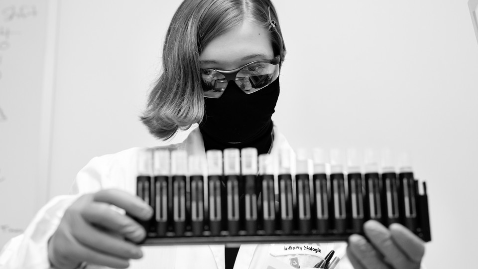 A woman in goggles with uncapped saliva samples