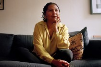 bell hooks sitting on a couch and smiling softly