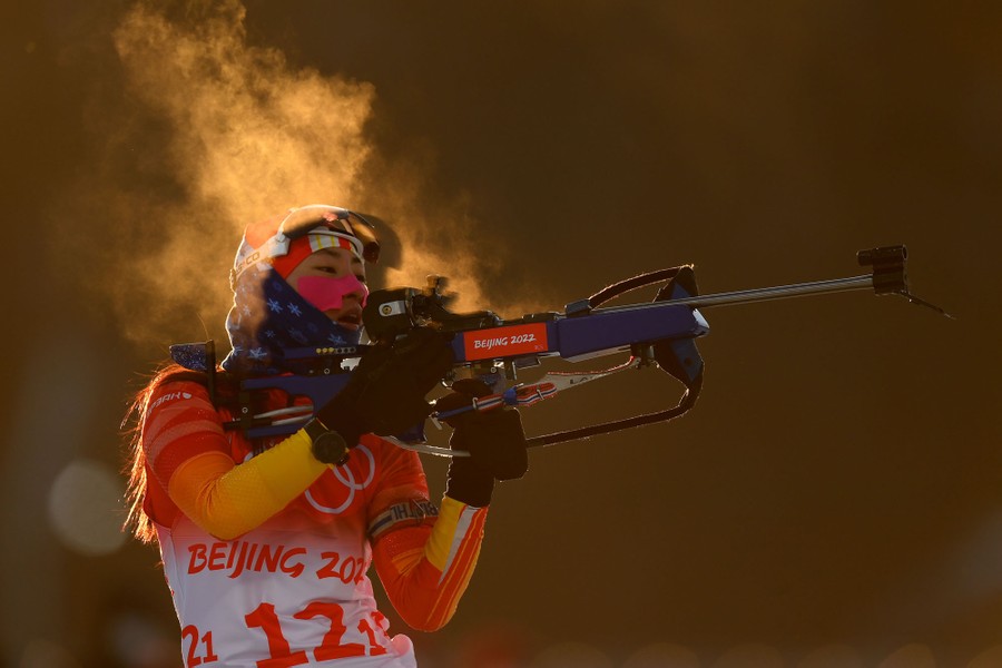 The breath of an athlete is seen in the cold air as they prepare to fire a rifle during a biathlon event.