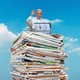 A photo illustration of Pope Francis on top of a stack of newspapers.