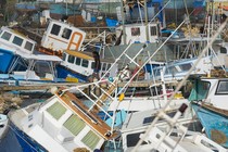 A fisherman looks at fishing vessels damaged by Hurricane Beryl at the Bridgetown Fisheries in Barbados on July 1, 2024.