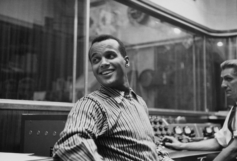 Harry Belafonte looks over his shoulder in a recording studio.
