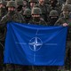 A group of Polish soldiers hold a NATO flag at a training in Orzysz, Poland, in July 2022.