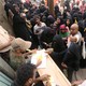 Several Hodeidah residents wait in front of a table, where workers distribute aid materials. 