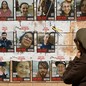 A woman walks in front of posters of hostages