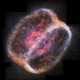 A giant shell of gas and dust surrounds a distant star. The shell is rounded and resembles red bell pepper that's been sliced in half.