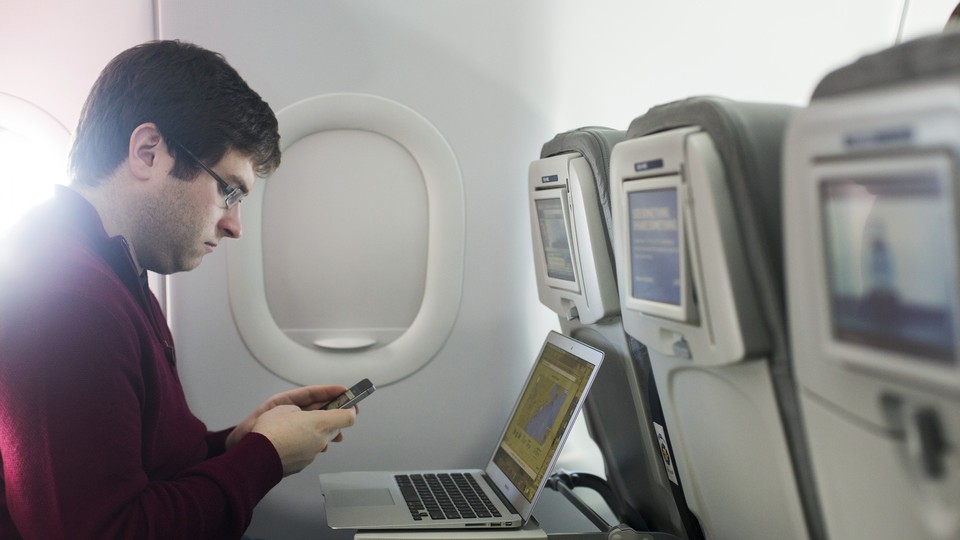 A man using his laptop on the plane