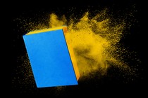 An illustration of a blue-and-yellow book disintegrating