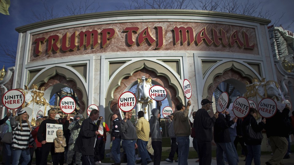 People picket with signs that say "Unite here" in front of the Trump Taj Mahal casino.