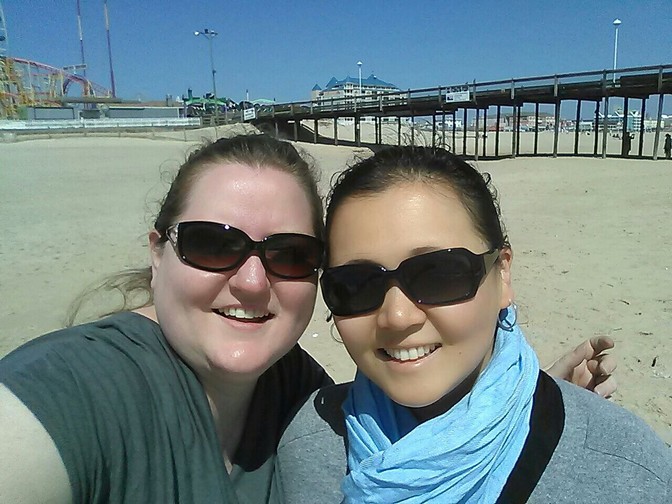 A selfie of two women in sunglasses on the beach