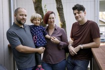 Three adults posing with a young child