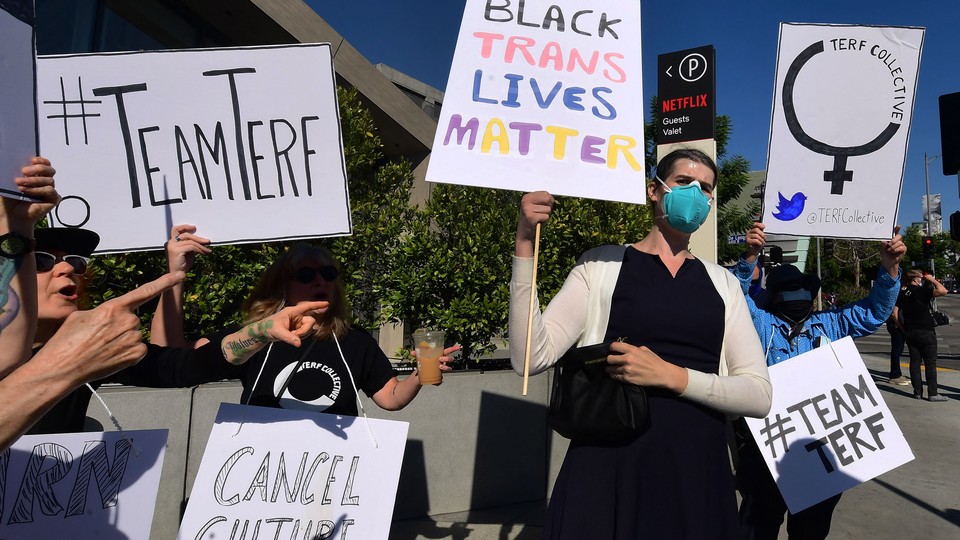 Supporters and dissenters at the Netflix trans solidarity walkout, holding sings like "Black trans lives matter" and "#TeamTERF"