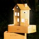 photo of cardboard moving boxes, one of which is shaped like a house
