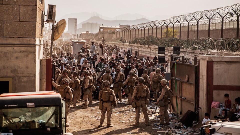 A photograph of crowds outside a gate to enter the Hamid Karzai International Airport in Kabul, Afghanistan.