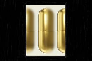 An image of three gold-colored pills, slightly blurred