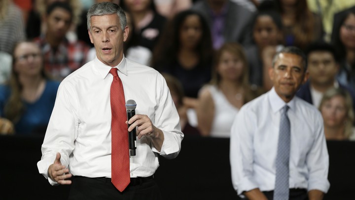 Duncan speaking into a microphone with Obama behind him