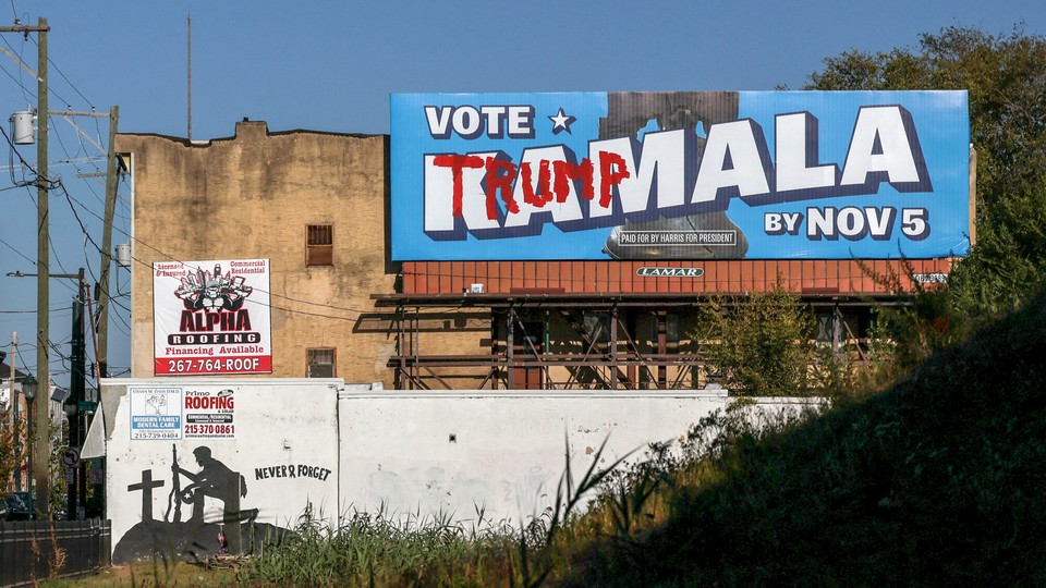 A “Vote Kamala” advertisement hangs defaced with “Trump” graffiti near a mural for fallen soldiers on Election Day in Philadelphia.
