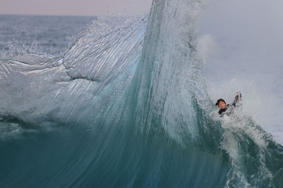 A young surfer is caught up in a spectacular wave.