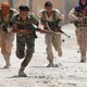 YPG fighters run through the streets of Raqqa, in Syria.