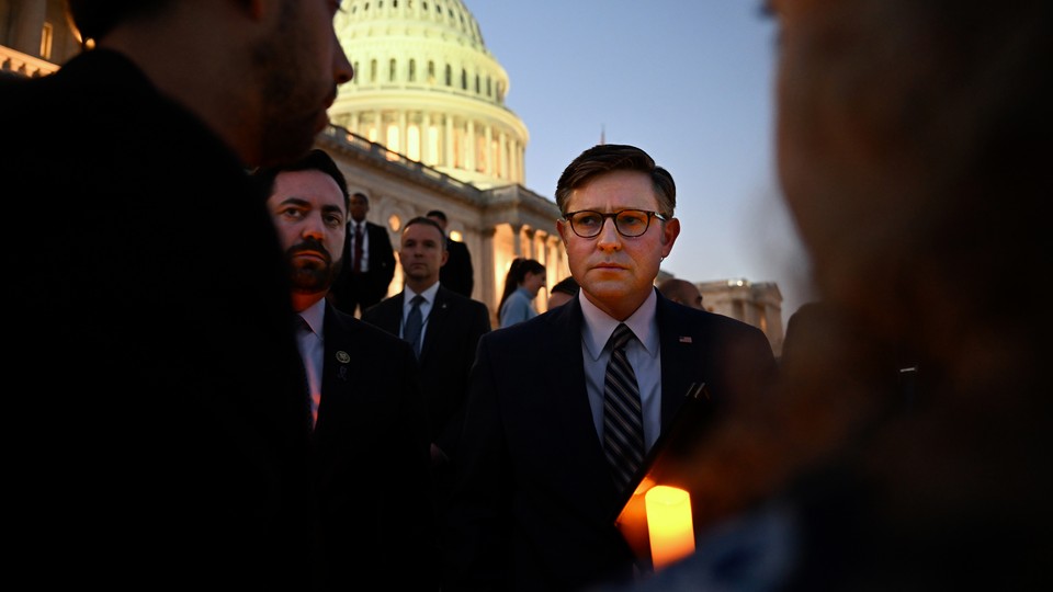 A photo of House Speaker Mike Johnson attending a candlelight vigil outside the U.S. Capitol.