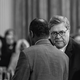black-and-white photo of Bill Barr and Ben Carson conferring with each other with audience in background