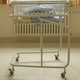Folded blankets sit atop a cart for newborn babies.