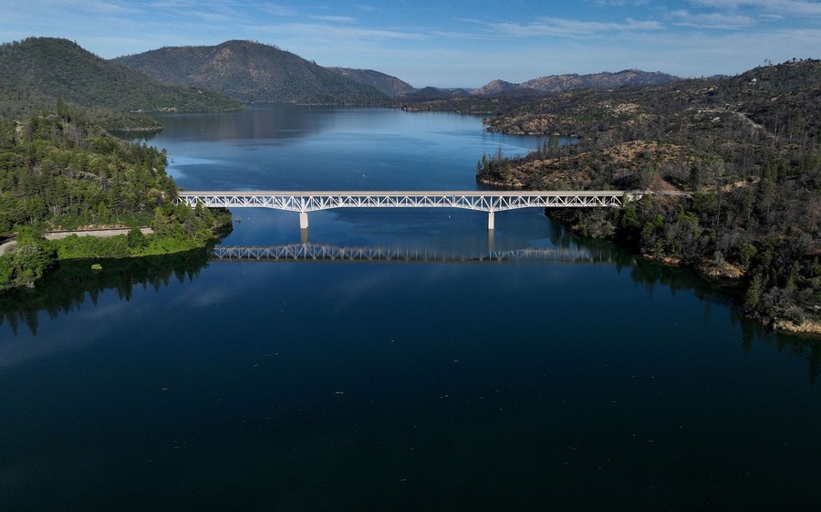 An aerial view of a full reservoir among hills in California