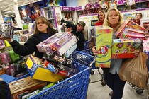 Women at Toys “R” Us hold boxes of toys.
