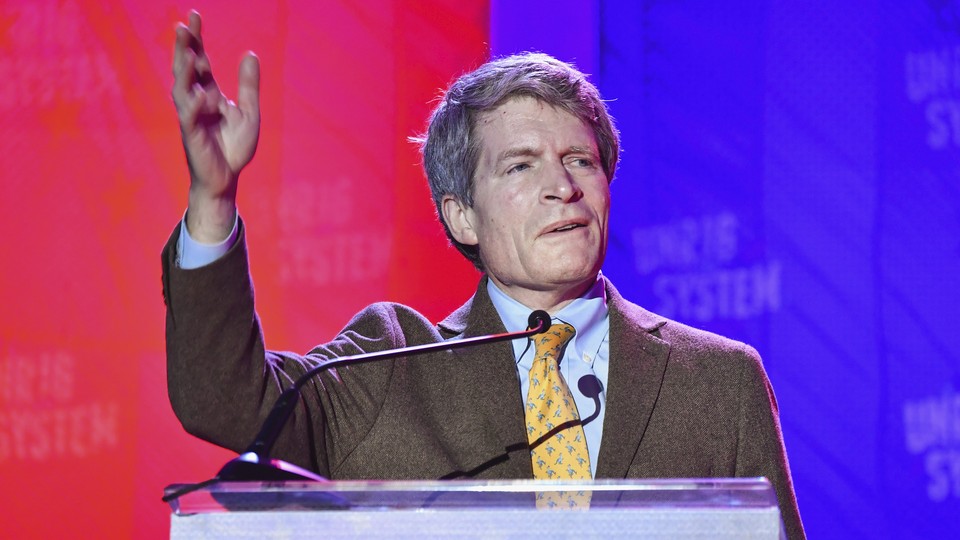Richard Painter waves his hand as he speaks to a crowd.
