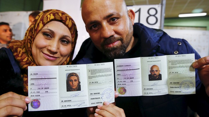 A Syrian couple presents their newly issued German registration documents.